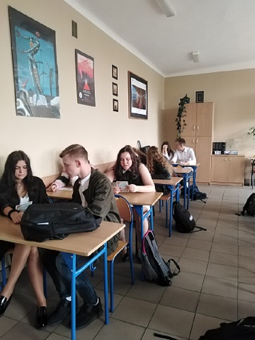 Uczniowie w klasie, siedzący w ławkach czytający książki