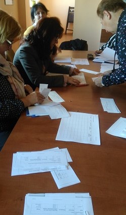 Nauczycielki wykonują zadania na spotkaniu, przy użyciu materiałów papierowych